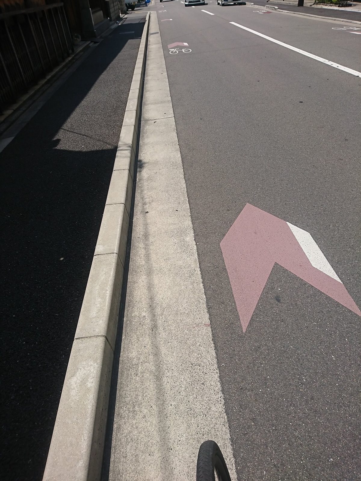 A painted arrow on the road surface marking the direction for bicycles
