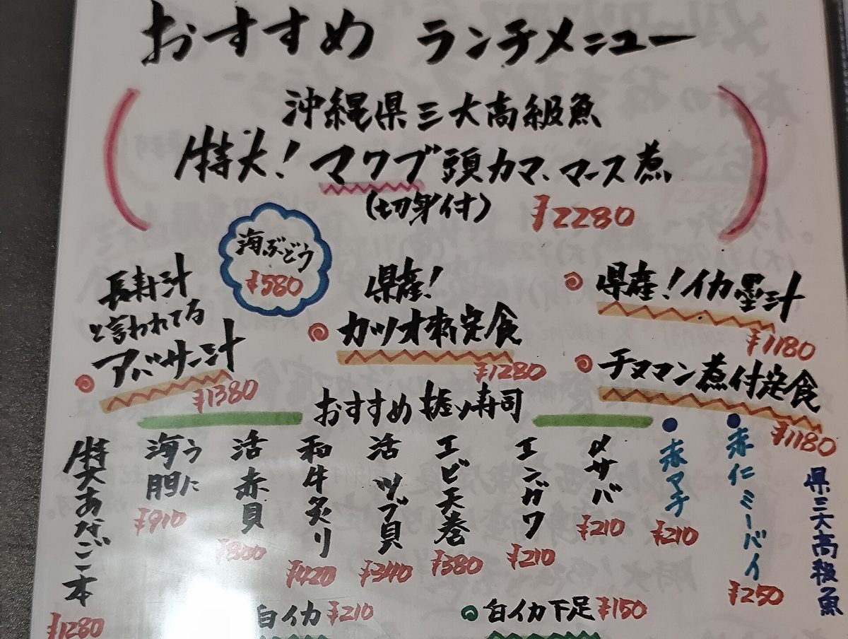 A handwritten Japanese lunch menu with dish names and prices in black and red ink