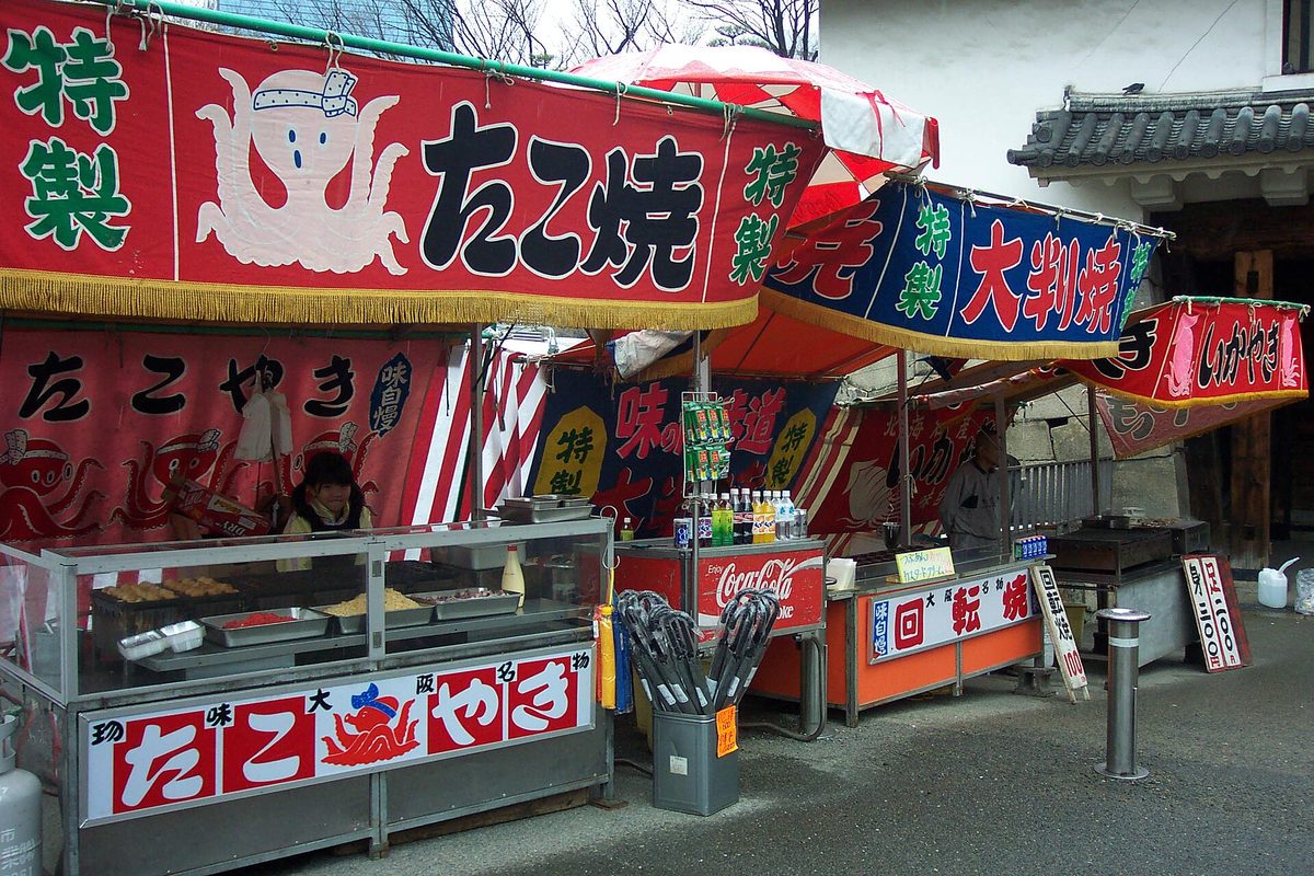 A takoyaki food stall with a bright octopus banner