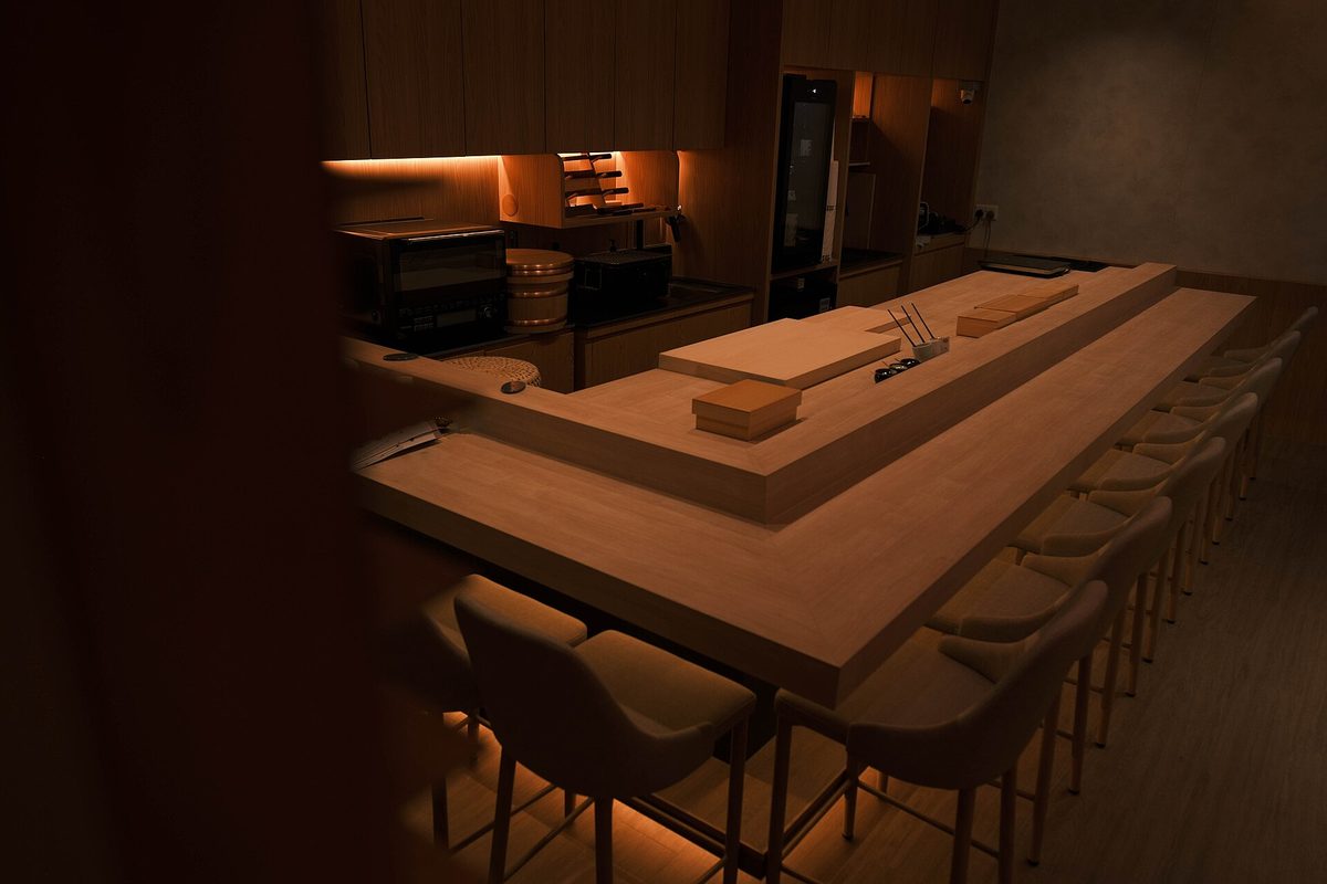 An empty wooden sushi counter with seats close together