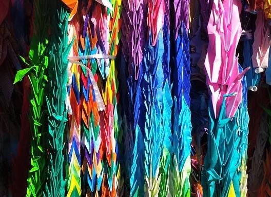 Strings of colorful folded paper cranes hanging in a booth at the Children's Peace Monument, Hiroshima (Hiroshima)