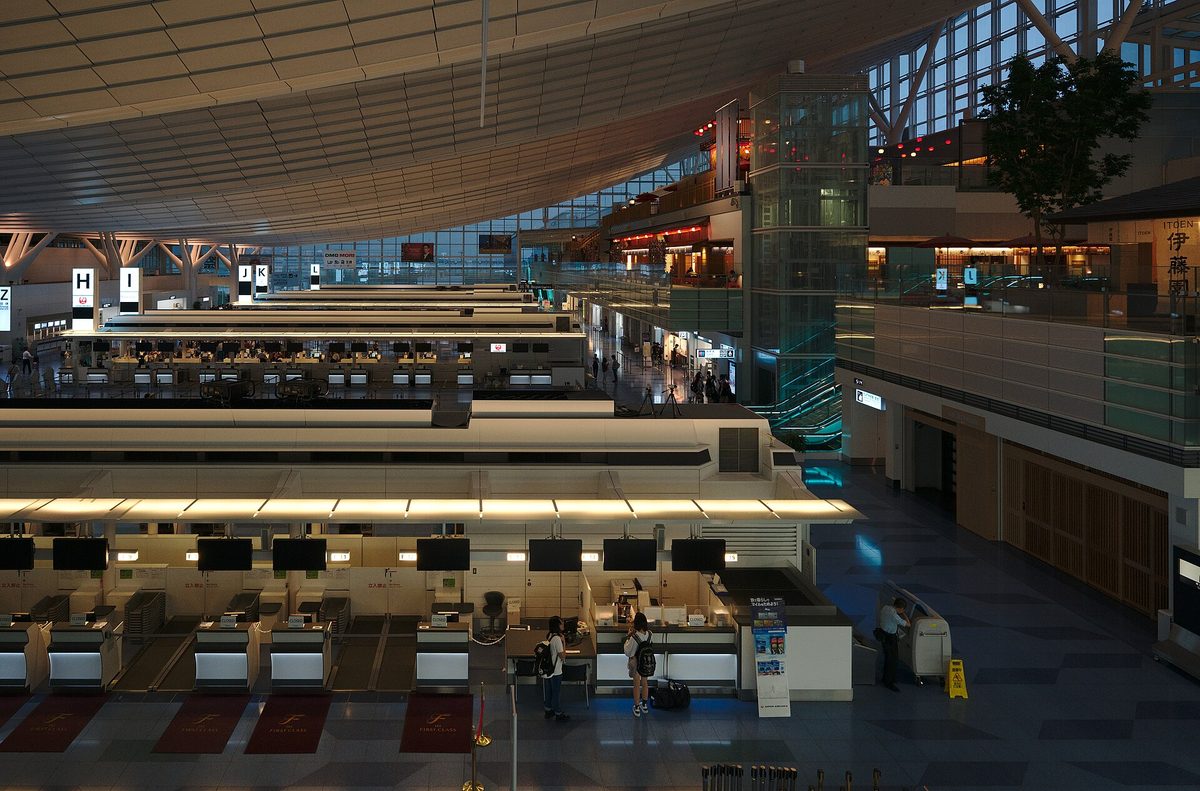 The long departure hall of Haneda Airport's international terminal with rows of check-in counters