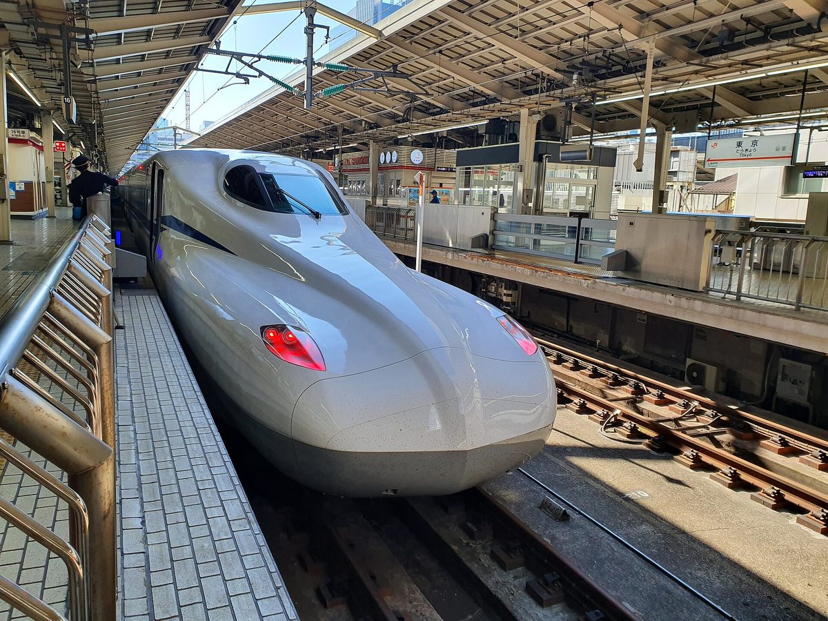A white N700 series Shinkansen train waiting at a platform at Tokyo Station