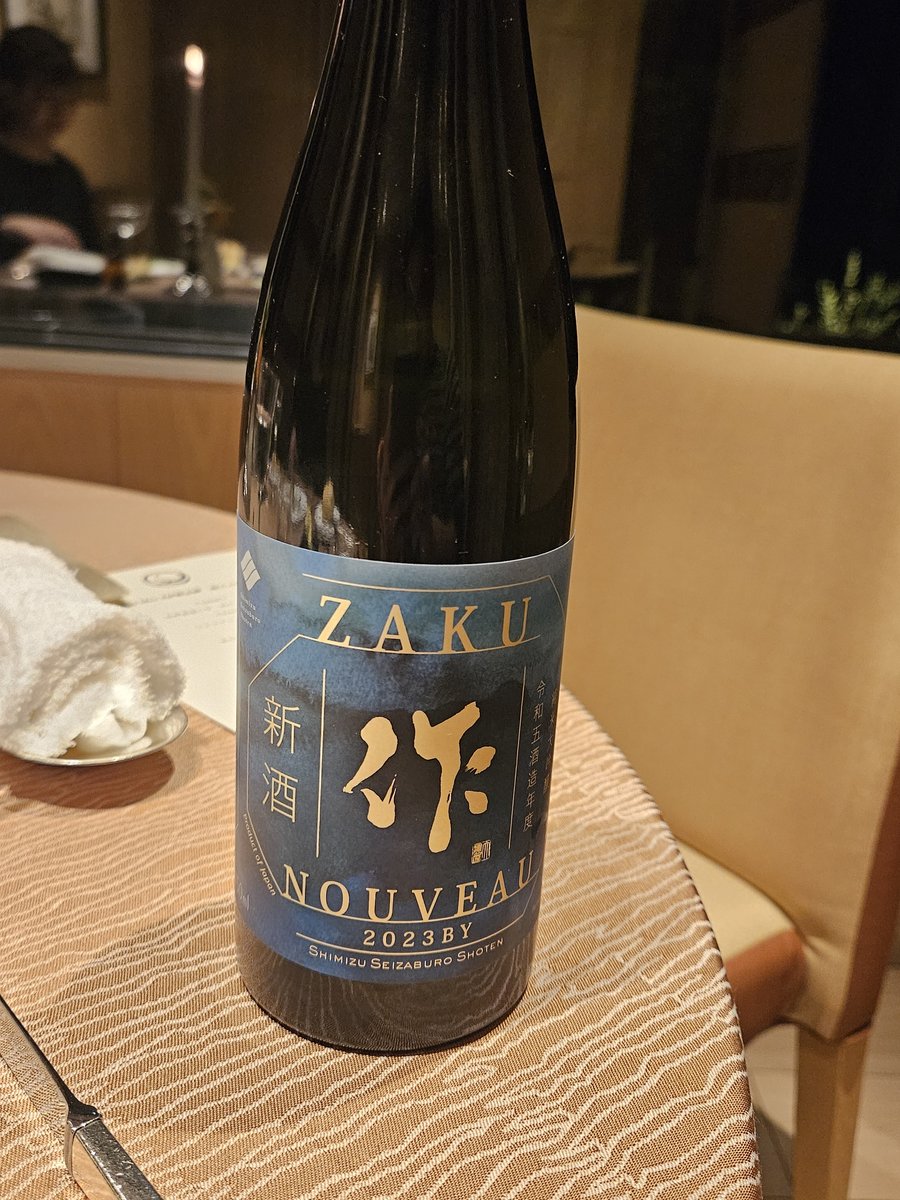 A bottle of Zaku sake on a dining table
