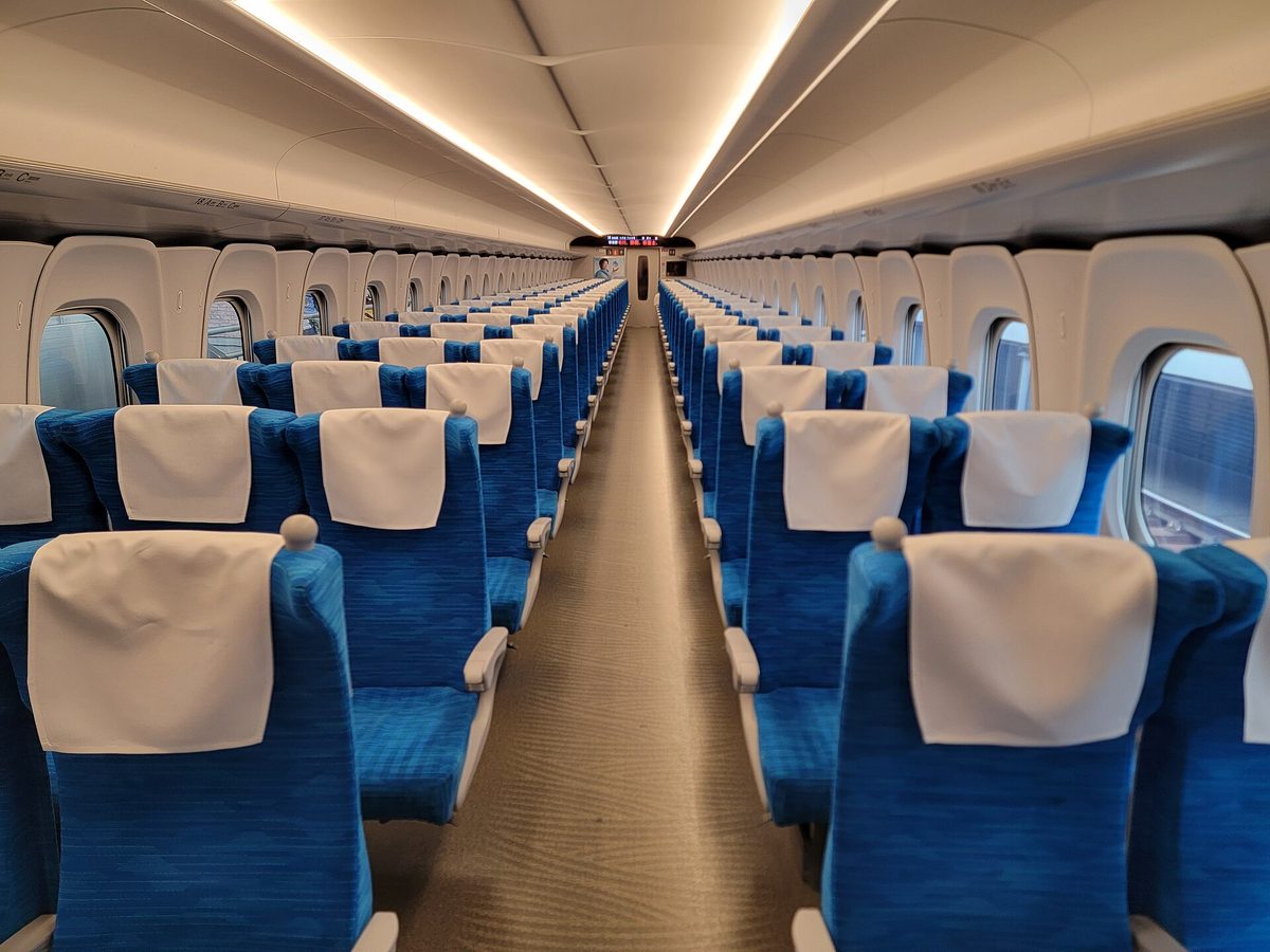 Rows of blue seats inside a Shinkansen car