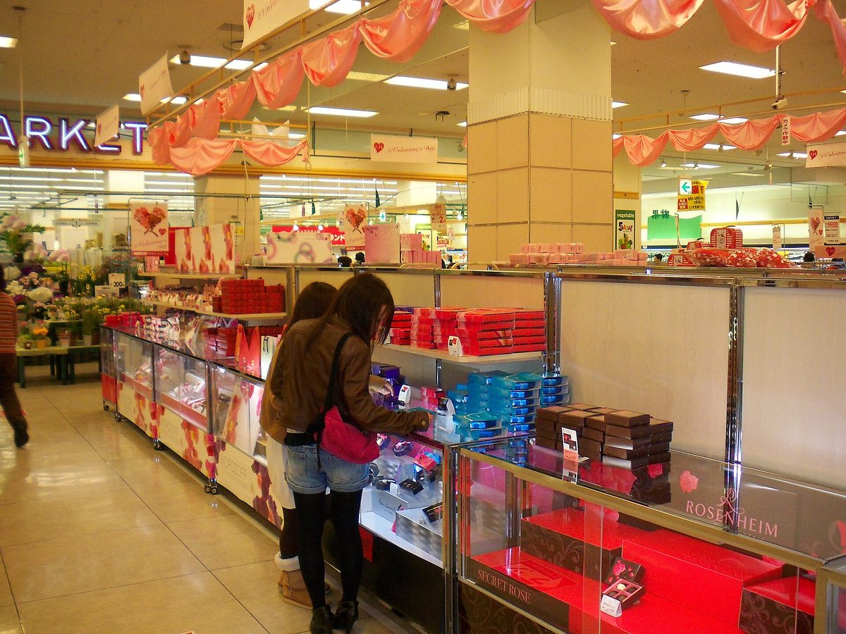 A Valentine's Day chocolate corner with pink and red displays in a Japanese shopping center